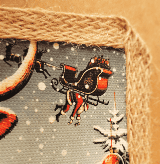 Zbliżenie na detale grafiki z zabawnym Mikołajem zwisającym z sań reniferów i trzymającym butelkę